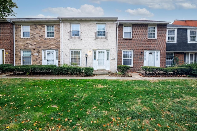 townhome / multi-family property featuring a front lawn