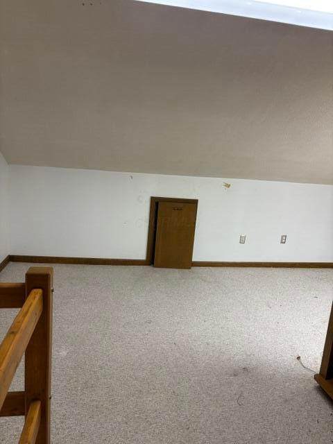 bonus room with carpet floors and vaulted ceiling