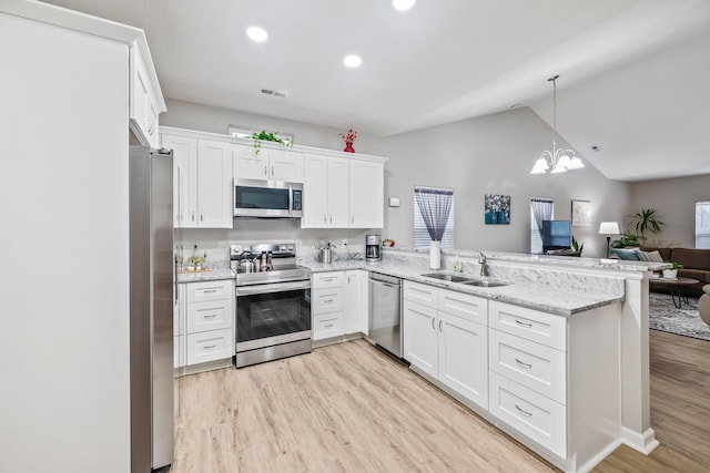 kitchen featuring appliances with stainless steel finishes, vaulted ceiling, sink, light hardwood / wood-style floors, and white cabinetry