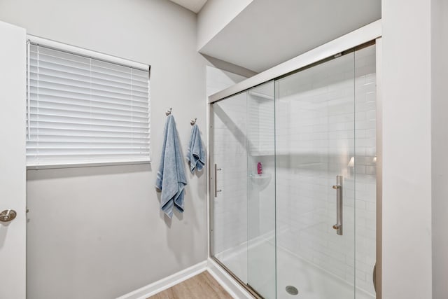 bathroom featuring wood-type flooring and a shower with door