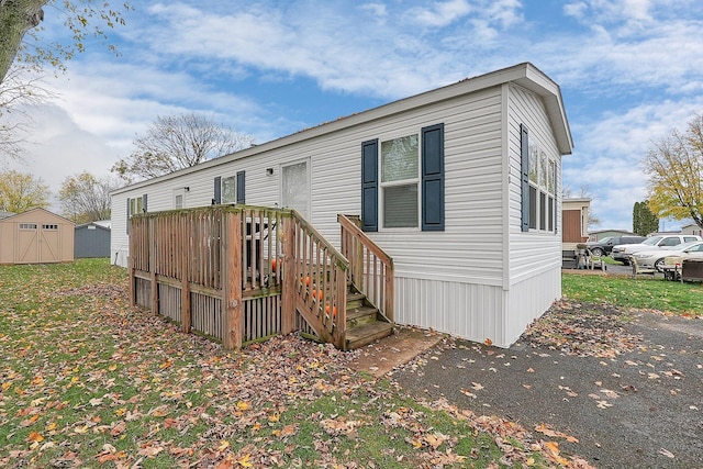 manufactured / mobile home with a deck and a storage shed