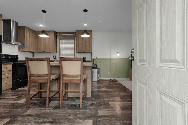 kitchen with wall chimney exhaust hood, dark hardwood / wood-style flooring, decorative light fixtures, and black / electric stove