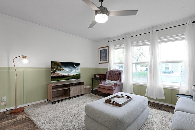 living room with hardwood / wood-style flooring, ceiling fan, and ornamental molding