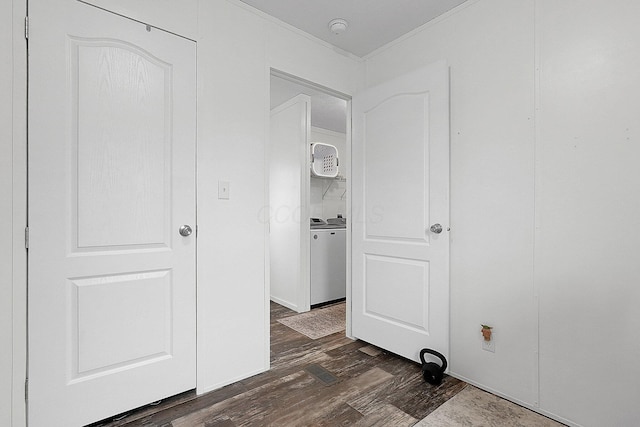 corridor featuring dark hardwood / wood-style floors, ornamental molding, and washer / clothes dryer