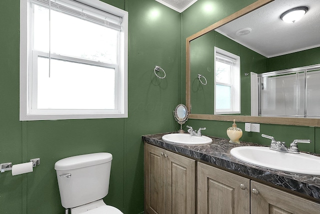 bathroom with a textured ceiling, vanity, an enclosed shower, and toilet