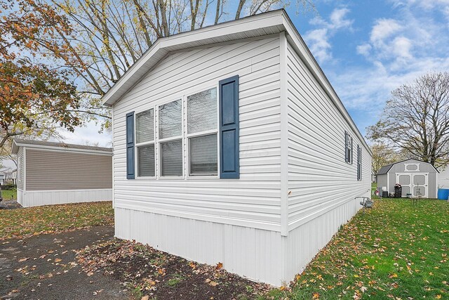 view of property exterior with a lawn and a shed