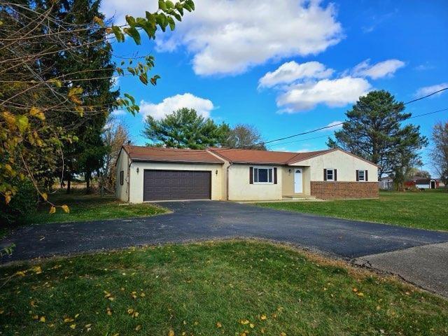 single story home with a garage and a front lawn