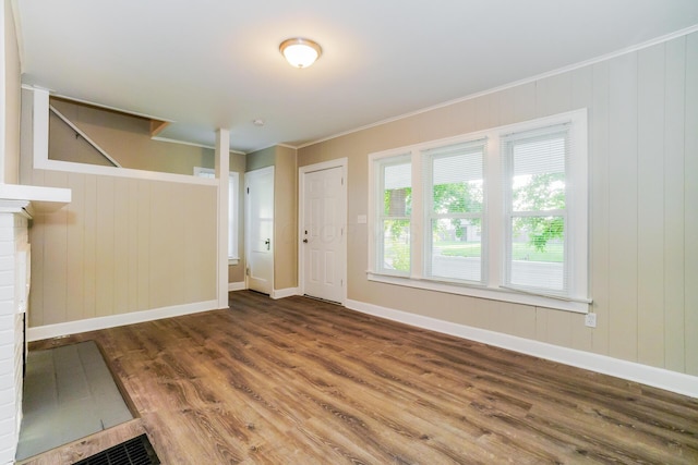 unfurnished living room with a fireplace, ornamental molding, and hardwood / wood-style flooring