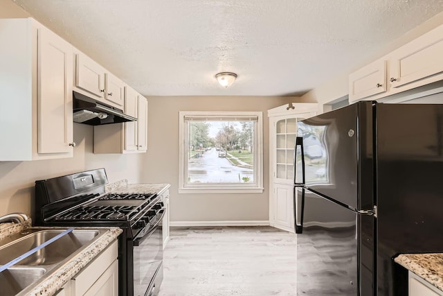 kitchen featuring a textured ceiling, sink, black appliances, white cabinets, and light hardwood / wood-style floors