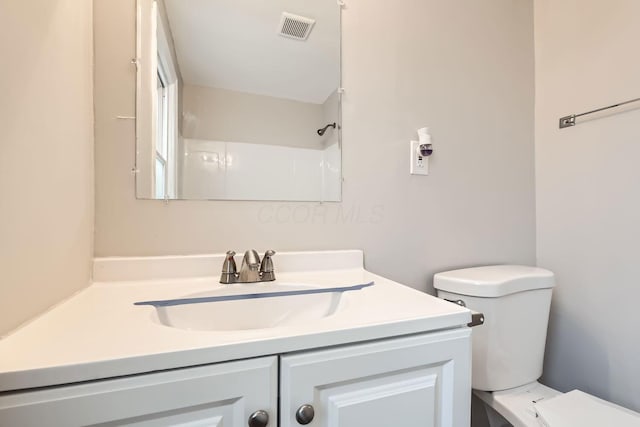 bathroom with a shower, vanity, and toilet