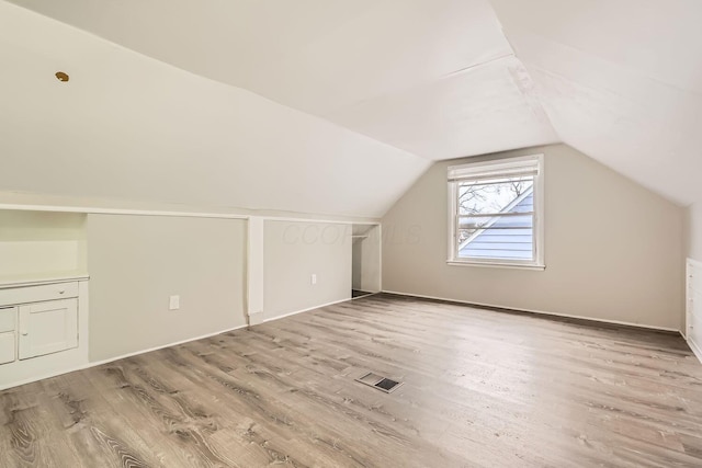 bonus room featuring light hardwood / wood-style floors and lofted ceiling