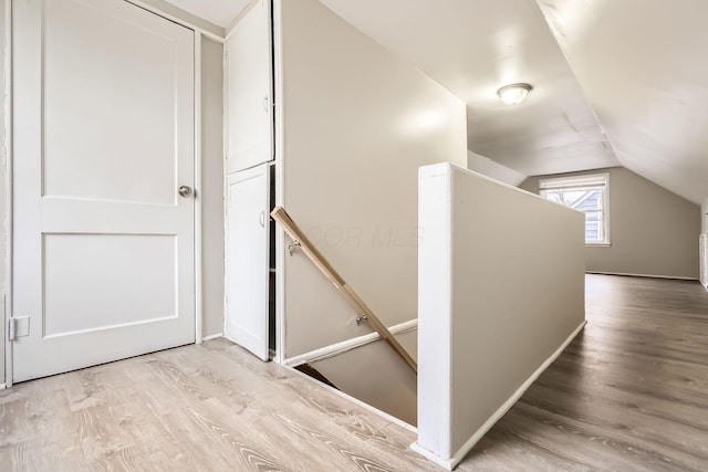 stairway featuring hardwood / wood-style floors and lofted ceiling