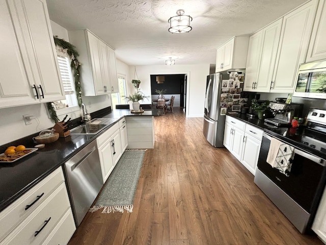 kitchen with sink, white cabinetry, stainless steel appliances, and dark wood-type flooring