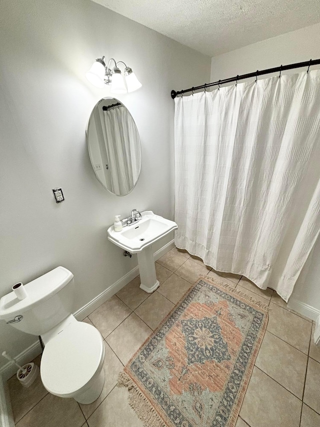 bathroom featuring tile patterned floors, a textured ceiling, and toilet