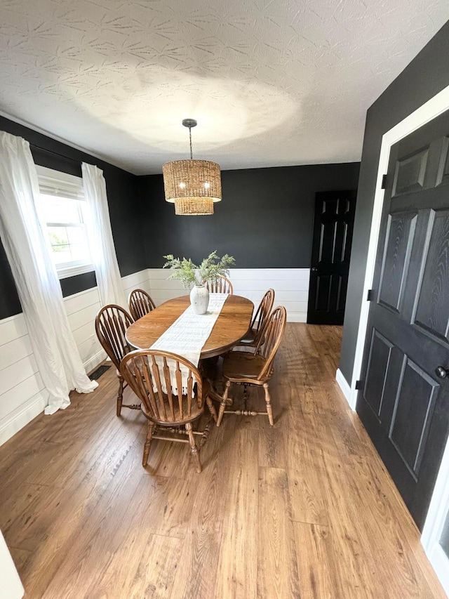 dining area featuring hardwood / wood-style floors and a textured ceiling