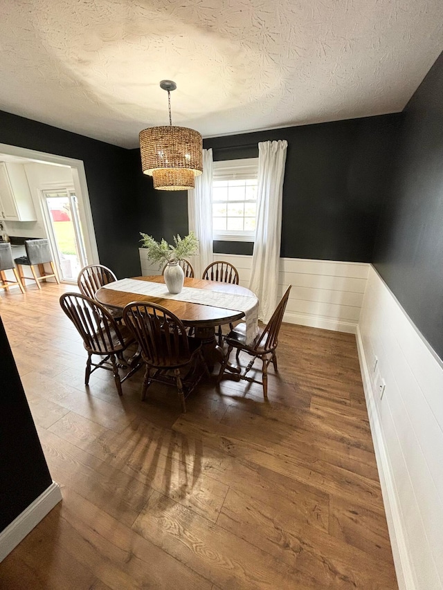 dining room with hardwood / wood-style flooring and a textured ceiling