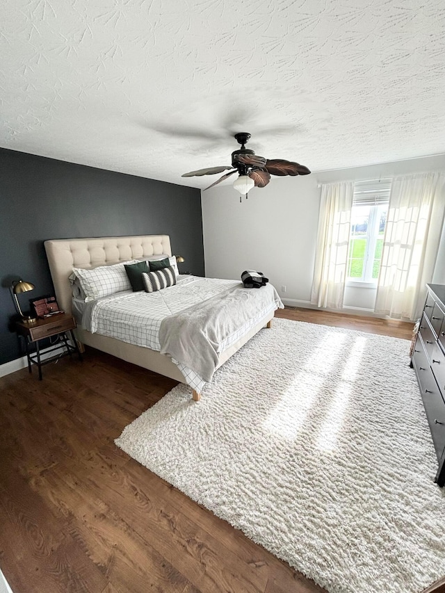 bedroom featuring a textured ceiling, dark hardwood / wood-style flooring, and ceiling fan