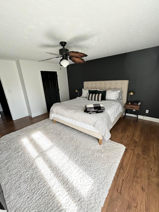 bedroom featuring a textured ceiling, a closet, dark hardwood / wood-style floors, and ceiling fan