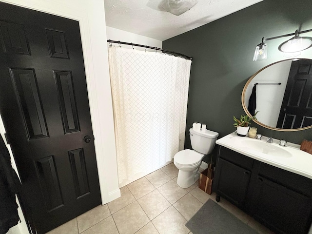 bathroom with tile patterned flooring, vanity, toilet, and a textured ceiling