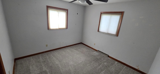 carpeted spare room featuring ceiling fan