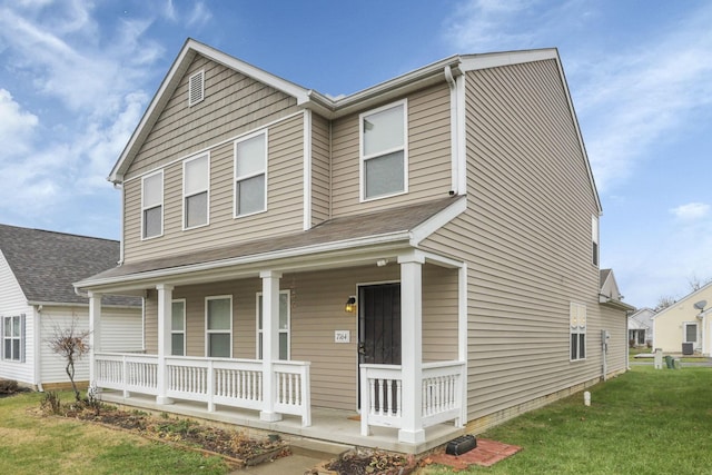 view of front of home with covered porch and a front lawn