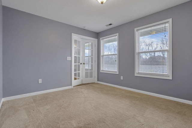 empty room with light colored carpet and french doors