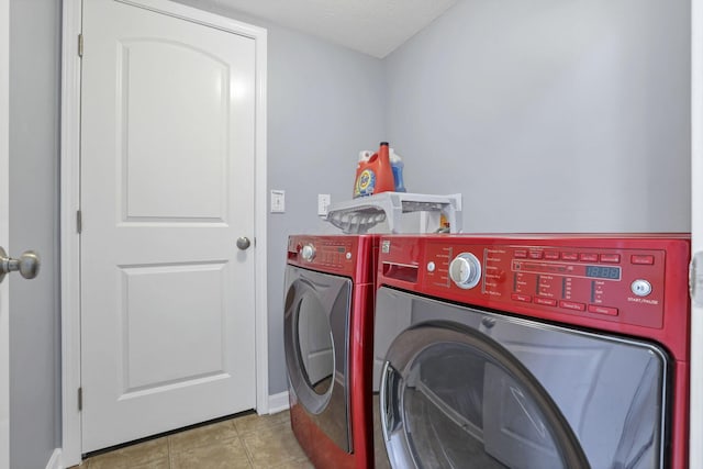 washroom with washer and dryer, light tile patterned floors, and a textured ceiling