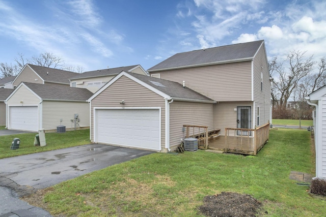 exterior space with central AC, a yard, and a garage