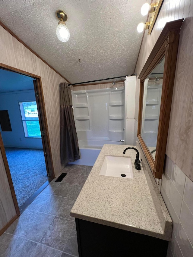 bathroom featuring vanity, a textured ceiling, shower / bathtub combination with curtain, and crown molding