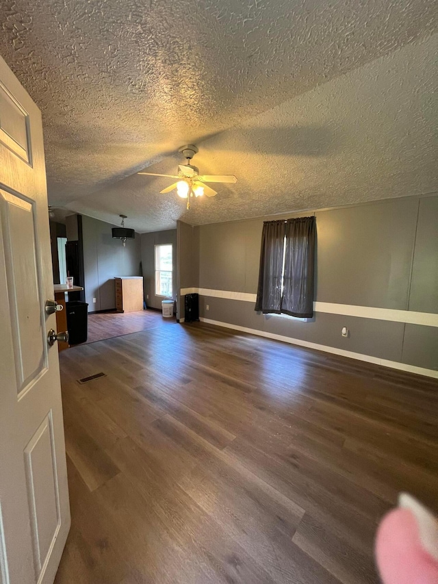 unfurnished room featuring hardwood / wood-style flooring, ceiling fan, and a textured ceiling