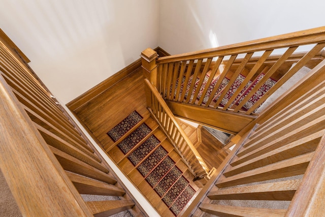 stairway with wood finished floors and baseboards