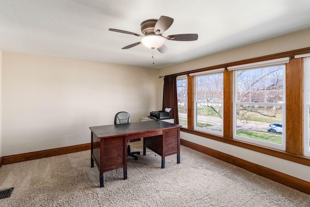 home office with light carpet, visible vents, baseboards, and ceiling fan