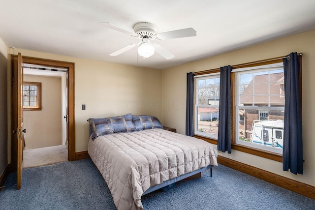 bedroom with multiple windows, a ceiling fan, and baseboards