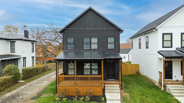 modern farmhouse style home featuring covered porch and a front yard