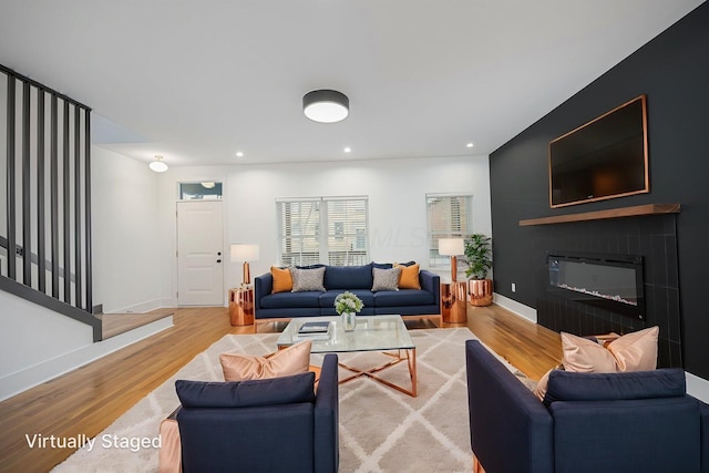 356 Miller Ave, Columbus, OH 43205 - living room with light wood finished floors, a glass covered fireplace, baseboards, recessed lighting, and stairs