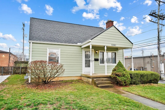 bungalow with covered porch and a front yard