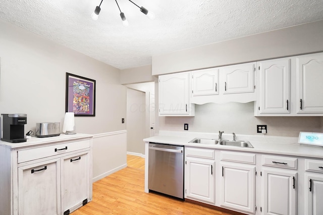 kitchen featuring sink, light hardwood / wood-style flooring, stainless steel dishwasher, a textured ceiling, and white cabinetry