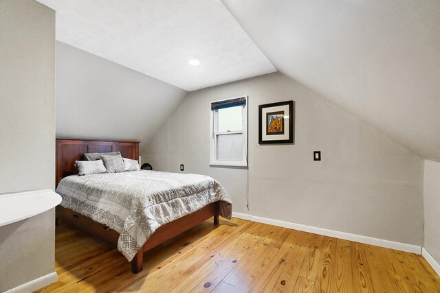 bedroom with light hardwood / wood-style floors and vaulted ceiling