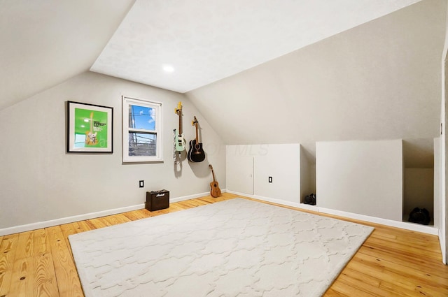 additional living space featuring hardwood / wood-style floors and vaulted ceiling