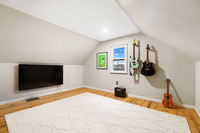 additional living space featuring wood-type flooring and vaulted ceiling