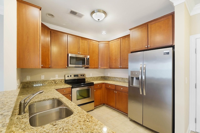 kitchen with light stone counters, sink, stainless steel appliances, and crown molding