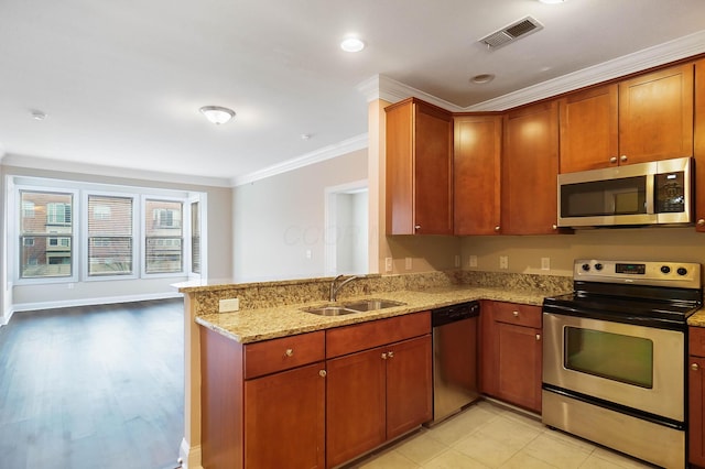 kitchen with light stone countertops, sink, stainless steel appliances, kitchen peninsula, and ornamental molding