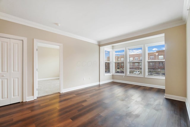 empty room featuring crown molding and dark hardwood / wood-style flooring