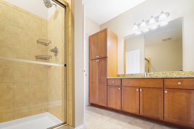 bathroom featuring tile patterned floors, a shower with door, and vanity