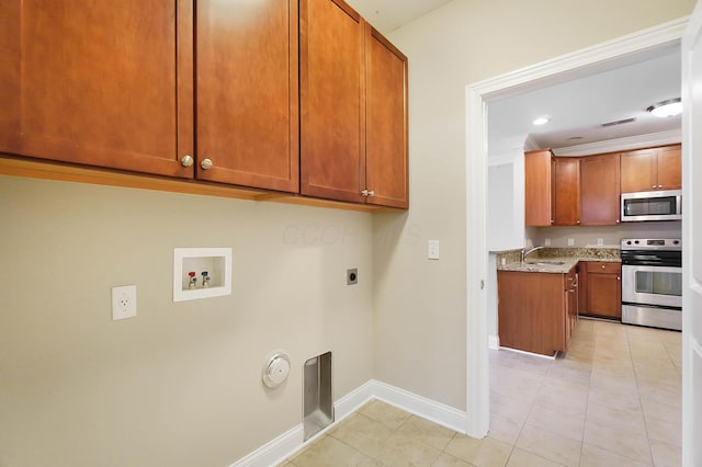 laundry area featuring washer hookup, ornamental molding, electric dryer hookup, sink, and light tile patterned floors