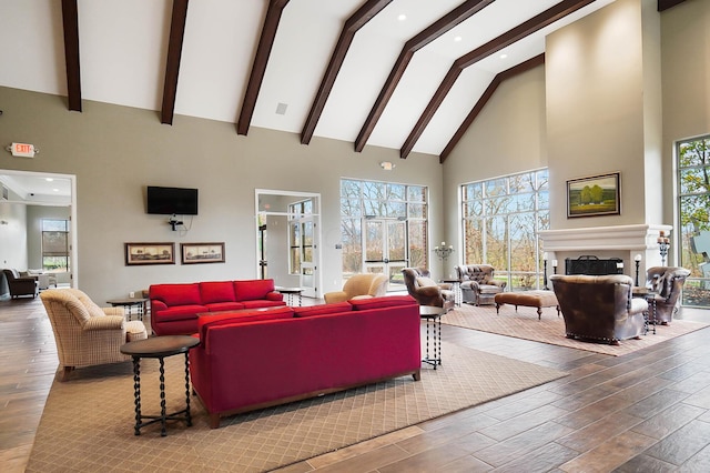 living room with wood-type flooring, high vaulted ceiling, plenty of natural light, and beam ceiling