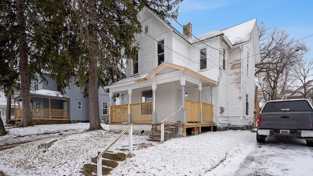 view of front of home with a porch and a chimney