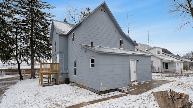 snow covered house with a shingled roof