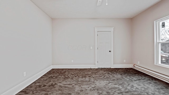 unfurnished room featuring a baseboard heating unit, carpet, ceiling fan, and baseboards