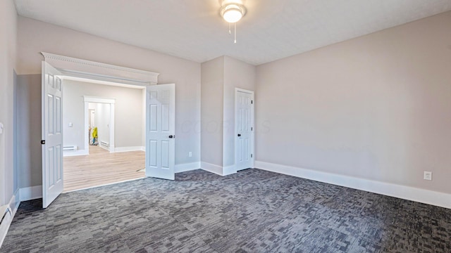 unfurnished bedroom featuring a ceiling fan, carpet, baseboards, and a baseboard radiator